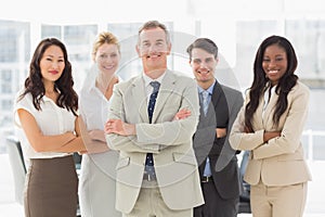 Business team smiling at camera with arms folded