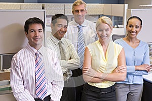 Business team standing in cubicle smiling