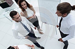 Business team standing in front of a flipchart.