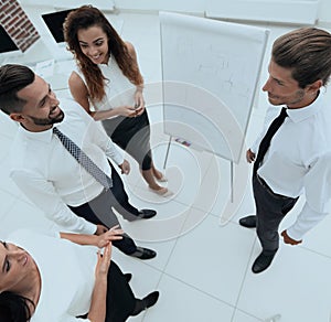 Business team standing in front of a flipchart.