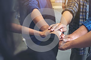 Business team standing and joining their hands together in office