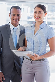 Business team with tablet pc smiling