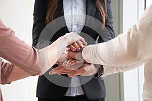 Business team of three people joining hands together, close up