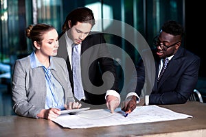 Business team of three reviewing project plan