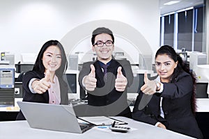 Business team with thumbs-up in office