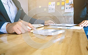 Business team using a calculator analysis data documents and using calculator
