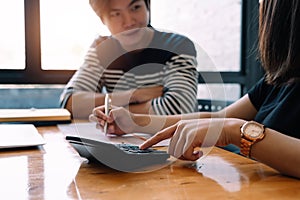 Business team using a calculator to calculate the numbers of statistic business profits growth rate on documents graph