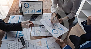 Business team using a calculator to calculate the numbers of statistic business profits growth rate on documents graph