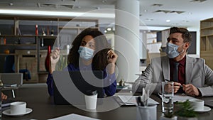 Business team wearing masks discuss corporate strategy in coronavirus pandemic.