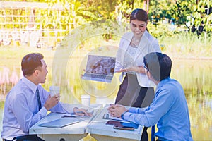 Business team work.They  are sitting on bench and talking in the park.