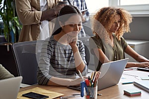 Business team at work. Young beautiful asian woman, female office worker working on laptop while sitting with colleagues