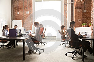 Business team workers working on computers in modern coworking enterprise