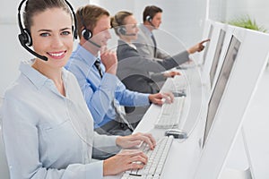 Business team working on computers and wearing headsets