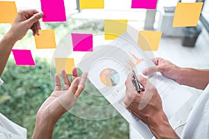 Business team working marketing growth on financial document graph report statistics, using post it notes in glass wall to writing