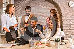 Business people working on new project and smiling. Man and women sitting together in modern office