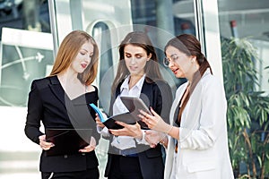 Business team working on a project. Three young people with devices. Concept for business, marketing, finance, work, colleagues