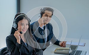 Business team working together at a call center wearing headsets