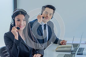 Business team working together at a call center wearing headsets