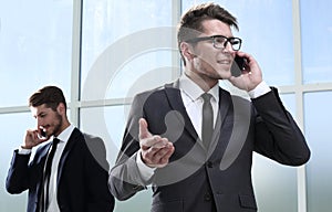 Businesspeople using technology in busy lobby area of office