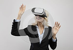 Business and technologies. Young businesswoman in VR headset experiencing virtual reality on light grey background
