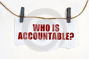 A sheet of paper with the inscription is attached to the rope with clothespins - WHO IS ACCOUNTABLE photo