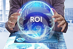 Business, Technology, Internet and network concept. Young businessman shows the word on the virtual display of the future: ROI photo