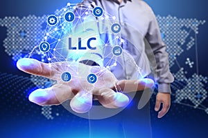 Business, Technology, Internet and network concept. Young businessman shows the word on the virtual display of the future: LLC photo