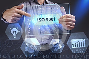 Business, Technology, Internet and network concept. Young businessman showing a word in a virtual tablet of the future: ISO 9001