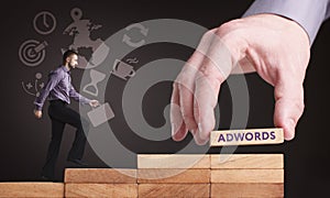 Business, Technology, Internet and network concept. Young businessman shows the word: AdWords photo
