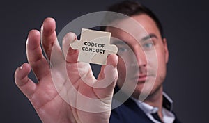 Business, Technology, Internet and network concept. Young businessman shows the word: Code of conduct