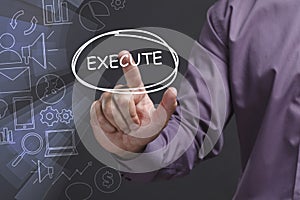 Business, Technology, Internet and network concept. Young businessman shows the word: Execute