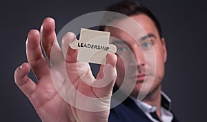 Business, Technology, Internet and network concept. Young businessman shows the word: Leadership