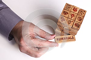 Business, Technology, Internet and network concept. Young businessman shows the word: Referrals