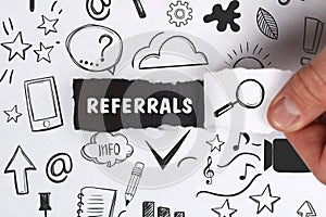 Business, Technology, Internet and network concept. Young businessman shows the word: Referrals