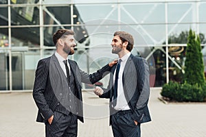 Business, technology and people concept. Image of two young businessmen communicating at meeting