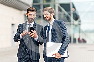 Business, technology and people concept. Image of two young businessmen communicating at meeting