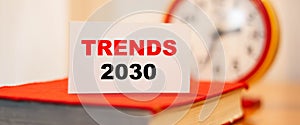 Business text - Trends 2030 on the background of the clock