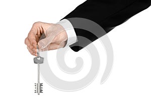 Business theme: real estate agent in the jacket in his hand the key to a new apartment on the white isolated background