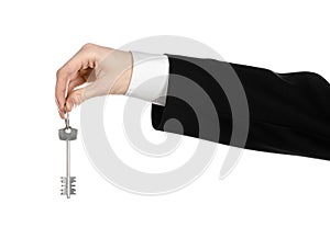 Business theme: real estate agent in the jacket in his hand the key to a new apartment on the white isolated background