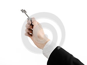 Business theme: real estate agent in the jacket in his hand the key to a new apartment on the white isolated background