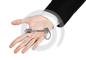 Business theme: real estate agent in the jacket in his hand the key to a new apartment on the white isolated background