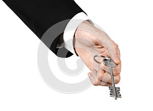 Business theme: real estate agent in the jacket in his hand the key to a new apartment on the white isolated background