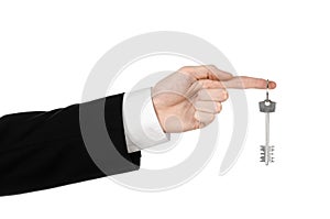 Business theme: real estate agent in the jacket in his hand the key to a new apartment on the white isolated background