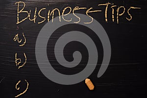 Business Tips written with color chalk. Supported by an additional services. Blackboard concept