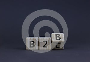 Business to Business or Busness to Customer symbol. Turned a wooden cube and changed words B2B to B2C. Beautiful grey background,