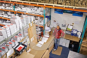 Business, top view and man in a warehouse for cargo, inventory or stock, quality control or management. Factory