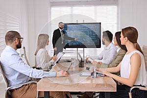 Business trainer using interactive board in meeting room during presentation photo