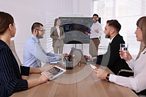 Business training. People in meeting room with interactive board