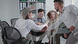 business training, a young successful work team supports each other by putting their hands in a circle during a