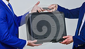 Business transfer concept. Male hand hold briefcase. Handover of case in hands of business partners. Handover of illegal